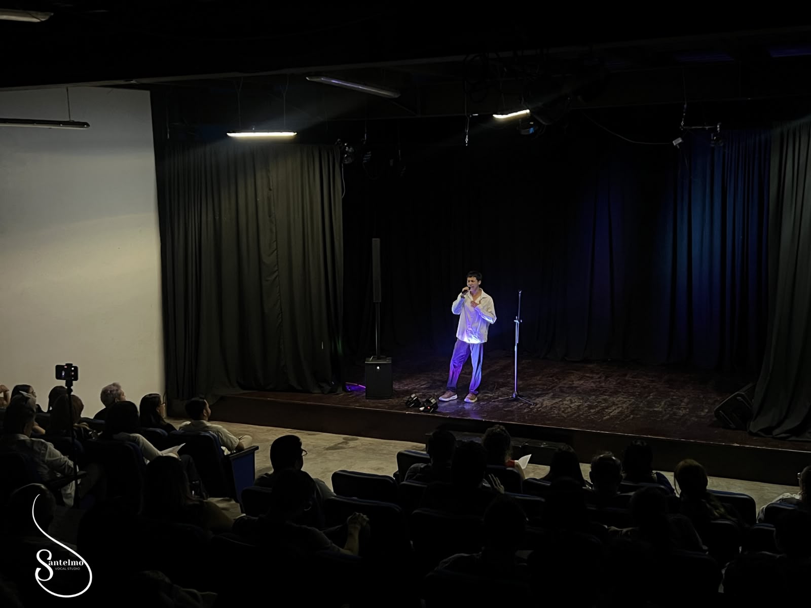Alumno cantando en un recital sobre el escenario
