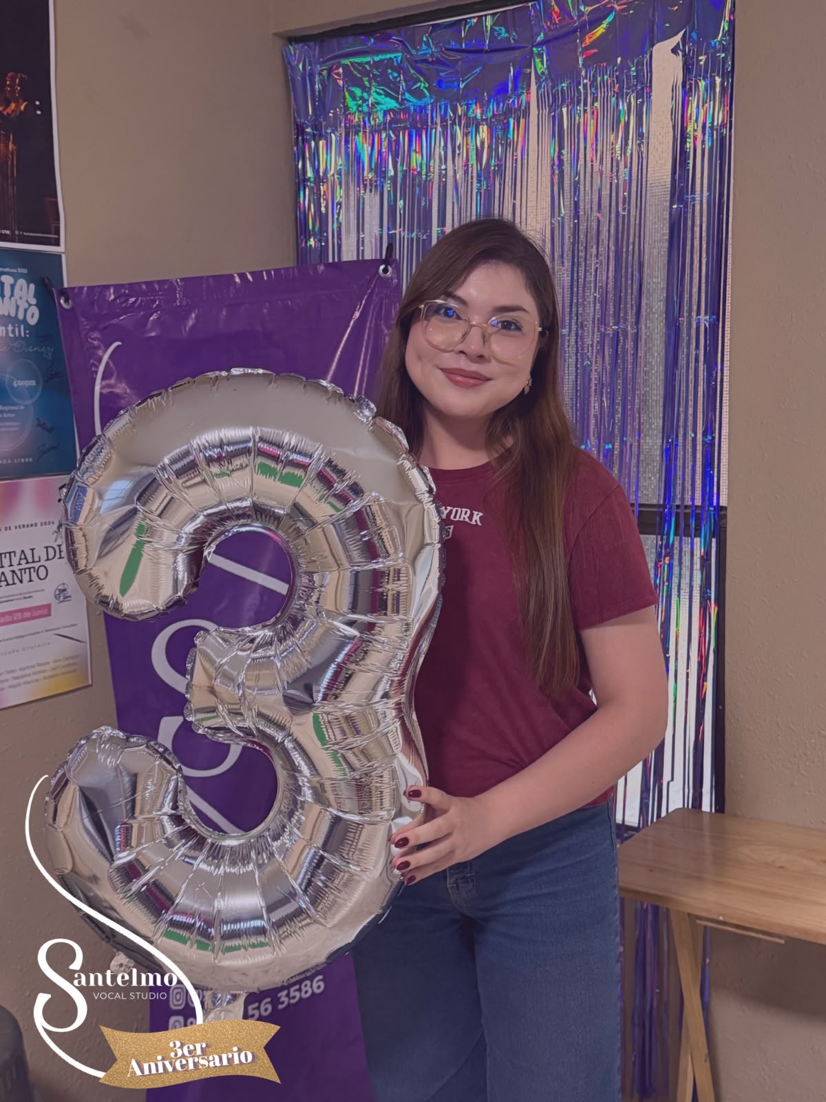 Maestra sosteniendo un globo del tercer aniversario del estudio